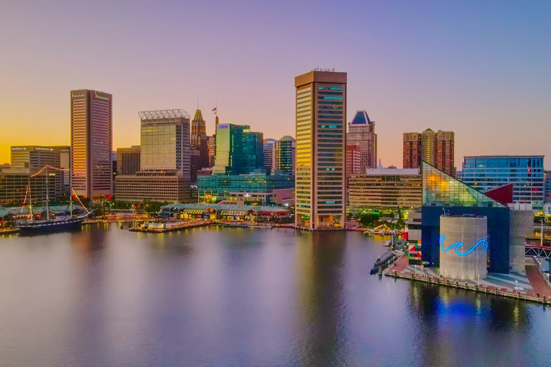 The Baltimore skyline and the National Aquarium across the Inner Harbor at dusk