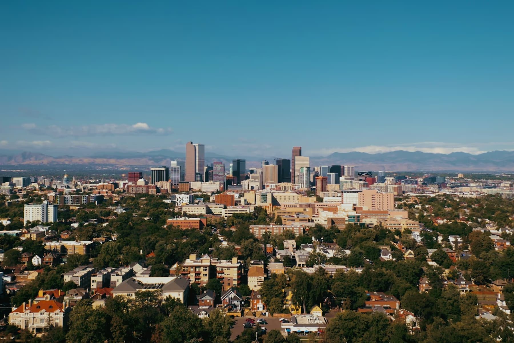 Aerial view of the downtown Denver skyline with the Rocky Mountains in the distance
