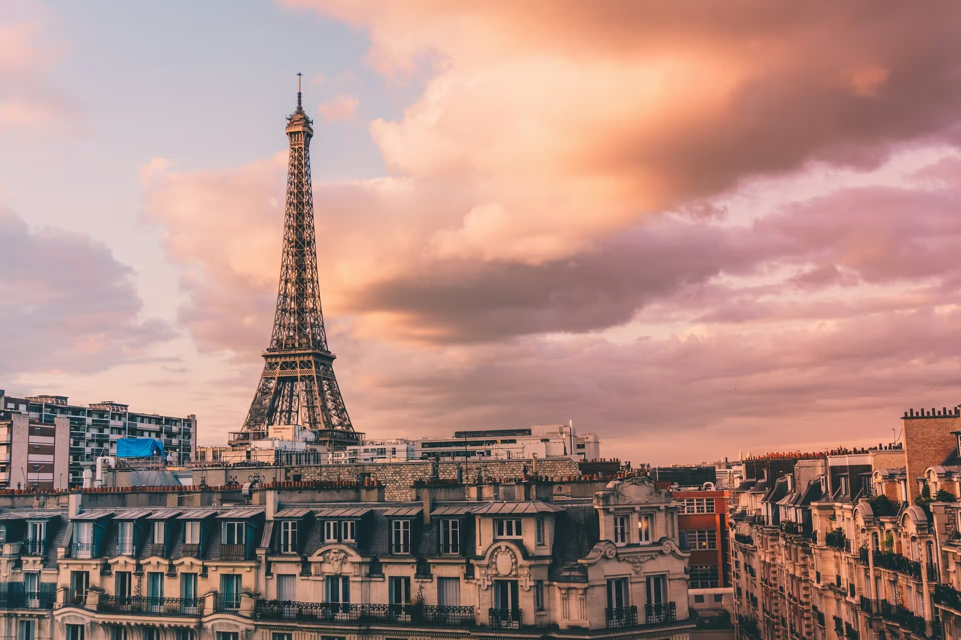 The Eiffel Tower above the rooftops of Paris at sunset