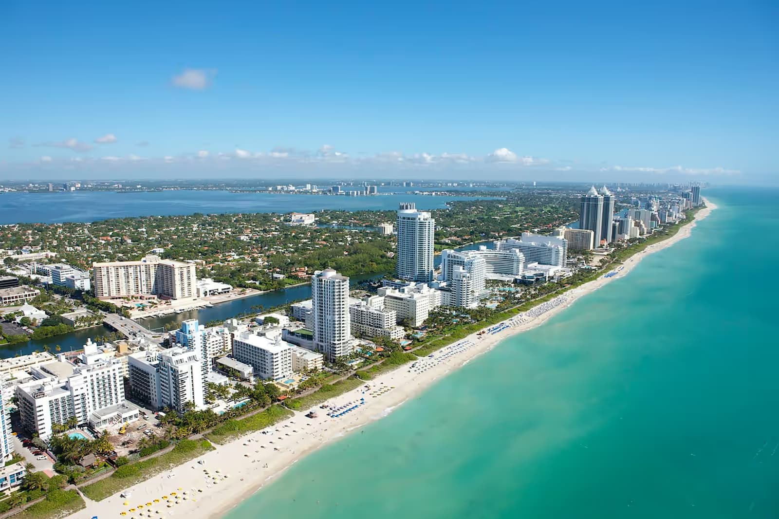 Aerial view of Miami Beach looking north along the sand and Collins Avenue, with Biscayne Bay on the left