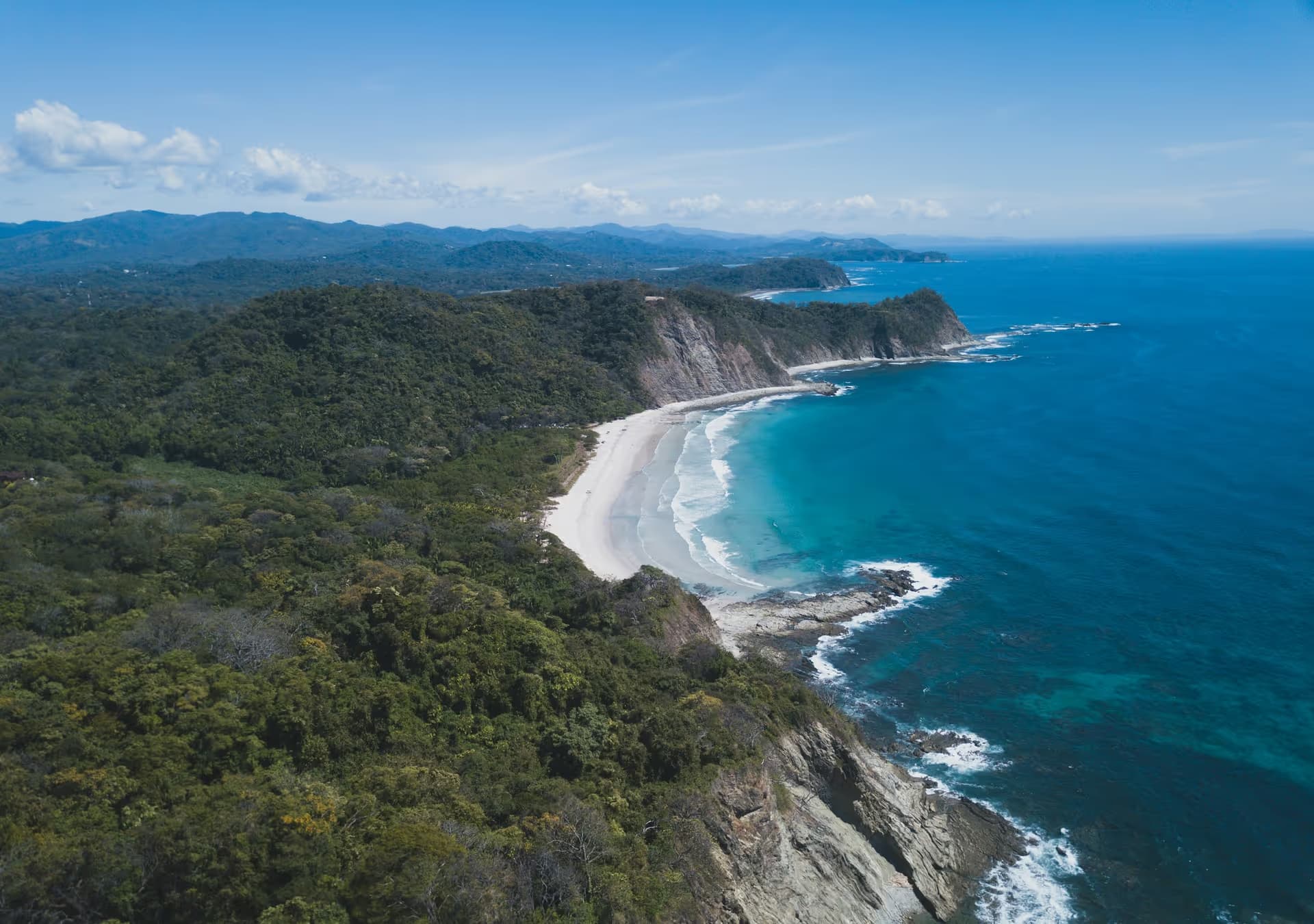 An aerial view of a sandy cove backed by dry forest on the Guanacaste coast of Costa Rica
